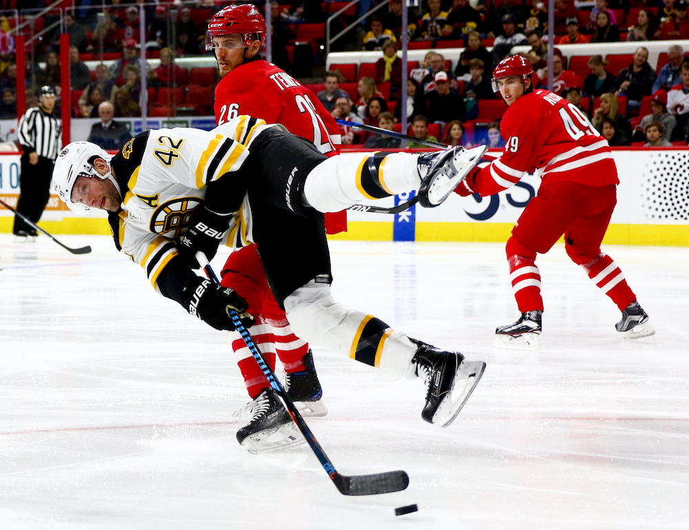 David Backes (42) leaves his feet to get off a shot. The Carolina Hurricanes defeated the Boston Bruins in overtime, by a score of 3-2, on December 23, 2016 in Raleigh, North Carolina. (Jerome Carpenter/WRAL Contributor)